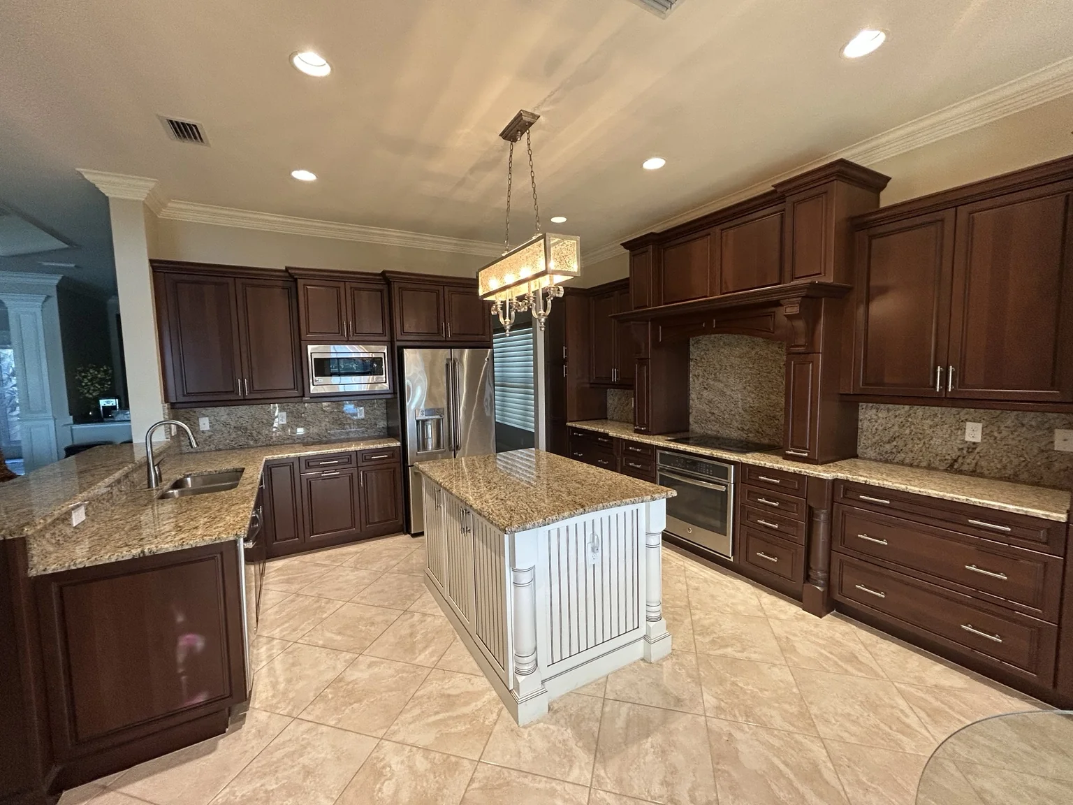 Dark stained kitchen cabinets before refinishing in Riverstone Naples